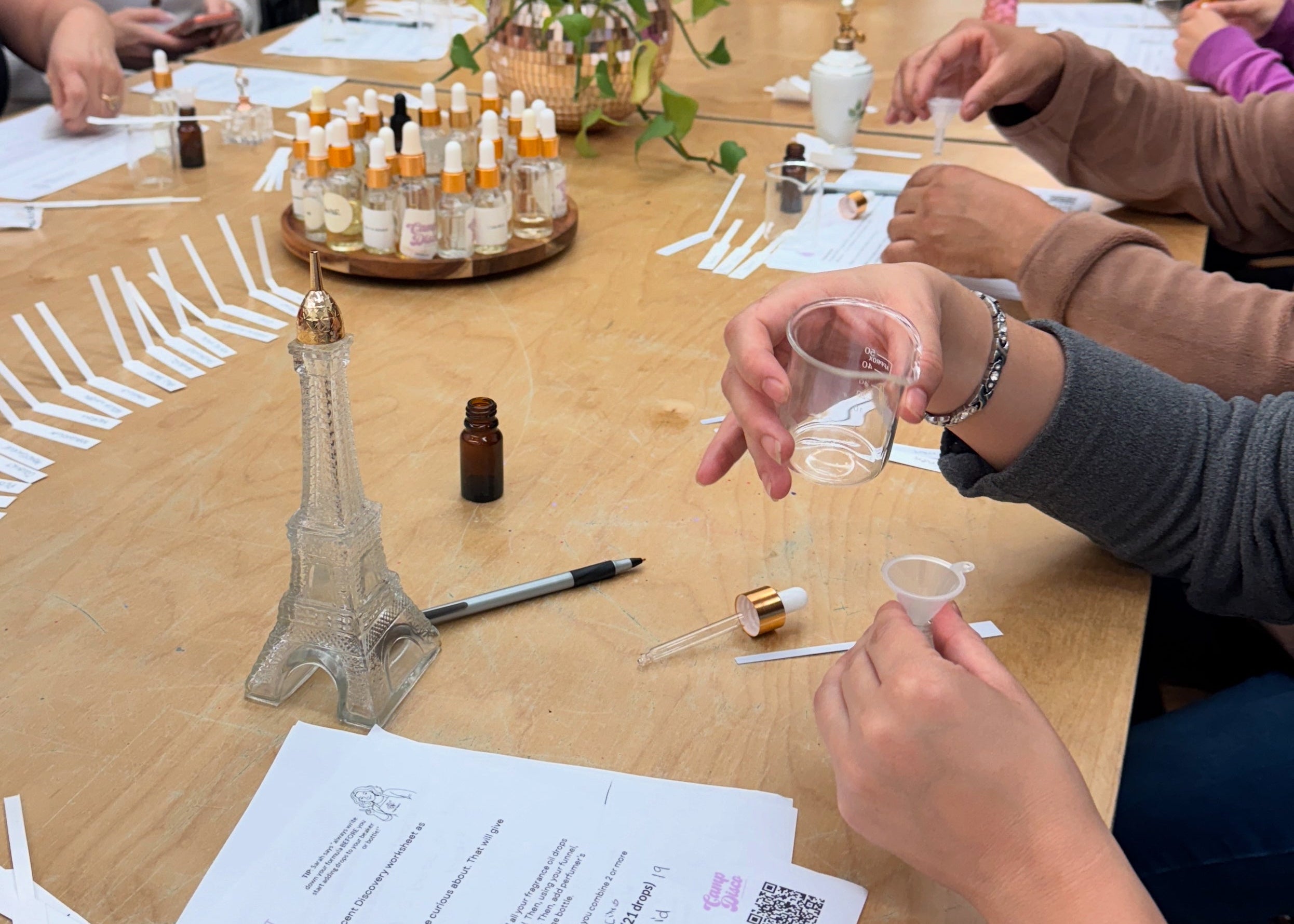 People at a table making perfume in a perfume making workshop